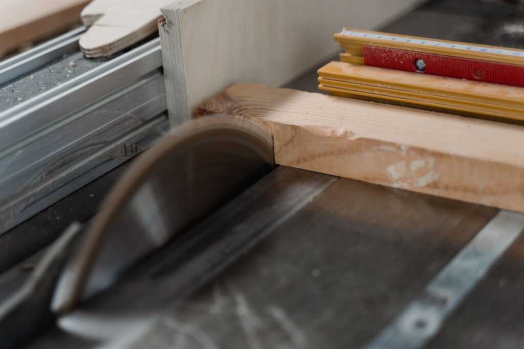 Table saw blade ripping a pine board along the fence